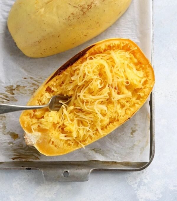 Spaghetti squash that has been halved, roasted and fluffed with a fork