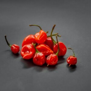 Bright red habanero chillies displayed on a black background